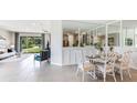 Bright dining area with white chairs and a view into the living room at 699 157Th E Ct, Bradenton, FL 34212