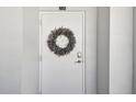 White condo front door with a lavender wreath at 7 Elgin Pl # 603, Dunedin, FL 34698