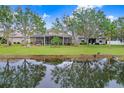Spacious backyard with screened patio, pond view, and lush landscaping at 11807 Summer Springs Dr, Riverview, FL 33579