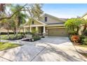 Front view of a charming house with a two-car garage and well-maintained landscaping at 15811 Oakleaf Run Dr, Lithia, FL 33547