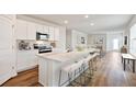 Modern kitchen with white cabinets, granite island, and stainless steel appliances at 17275 Whiskey Creek Trl, Parrish, FL 34219