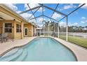 Relaxing screened-in pool with tiled deck overlooking a lake at 19820 Morden Blush Dr, Lutz, FL 33558