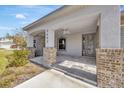 Covered front porch with brick columns and tile flooring at 2402 Cumberland Cliff Dr, Ruskin, FL 33570
