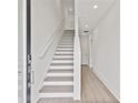 Modern staircase with white risers and gray treads, hardwood floors, and white walls at 2506 W Cleveland St # 18, Tampa, FL 33609