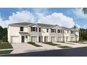 New townhouses with attached garages and landscaping at 31283 Midnight Sun Way, Wesley Chapel, FL 33545