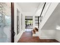 Bright entryway with brick flooring, glass door, and staircase at 5906 N Kenneth Ave, Tampa, FL 33604