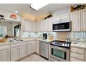 Well-equipped kitchen with stainless steel appliances and white cabinetry at 8086 Annwood Rd, Seminole, FL 33777
