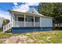 Charming light blue house with a white porch and well-maintained lawn at 2314 E 12Th Ave, Tampa, FL 33605