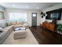 L-shaped sofa, dark hardwood floors, and a large TV at 434 29Th N Ave, St Petersburg, FL 33704