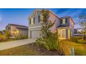Two-story house with gray siding, two-car garage, and landscaping at 5913 Laurelcrest Gln, Palmetto, FL 34221