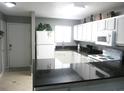 Modern kitchen with white cabinets, black countertops, and stainless steel appliances at 6033 34Th W St # 45, Bradenton, FL 34210