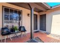 Small front porch with seating for two and potted plants at 7028 Oakview Cir, Tampa, FL 33634