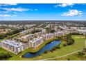 An aerial view showcasing a community of condominiums near a scenic lake and golf course at 960 Starkey Rd # 7103, Largo, FL 33771