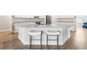 Well-lit kitchen features a large island with granite countertops and modern stools at 10920 Flint Estates Dr, Thonotosassa, FL 33592