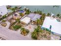 Aerial view of a home on a canal with a neighboring property undergoing demolition at 11325 6Th E St, Treasure Island, FL 33706