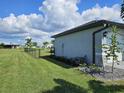 Landscaped side yard with a black chain link fence at 16064 Minorca Dr, Punta Gorda, FL 33955