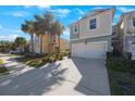 Two-story townhome with white garage door and walkway at 1608 Sunset Wind Loop, Oldsmar, FL 34677
