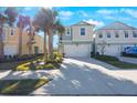 Two-story townhome with white garage door and palm trees at 1608 Sunset Wind Loop, Oldsmar, FL 34677