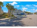 Street view of townhomes with palm trees and parked cars at 1608 Sunset Wind Loop, Oldsmar, FL 34677