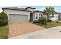 Single-story home with gray siding, brown roof, and a brick driveway at 19771 Ship Wheel Way, Land O Lakes, FL 34638