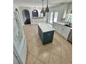 Open kitchen with an island, stainless steel appliances, and white cabinets at 24932 Ravello St, Land O Lakes, FL 34639