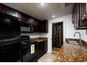 Galley kitchen with dark wood cabinets and granite counters at 331 25Th S St, St Petersburg, FL 33712