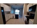 Modern kitchen with white cabinets, granite countertops, and stainless steel appliances at 4410 Summer Savory St, Tampa, FL 33619