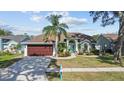 Charming single-story home featuring a well-manicured lawn, mature trees, and a welcoming front entrance at 731 Brittany Park Blvd, Tarpon Springs, FL 34689