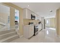 Modern kitchen with white cabinets, stainless steel appliances, and tiled floors at 7803 Cadillac Ave, Hudson, FL 34667