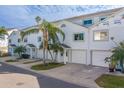 White two-story townhouses with attached garages and palm trees at 905 Hidden Harbour Dr, Indian Rocks Beach, FL 33785
