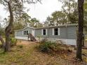 Gray manufactured home with wood steps and landscaping at 12816 Midvale Ave, New Port Richey, FL 34654