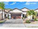 Two-story house with a brown garage door and nicely landscaped yard at 16909 April Plush Dr, Wimauma, FL 33598