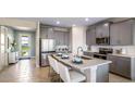 Modern kitchen with gray cabinets, island, and stainless steel appliances at 17932 Tavernside Trl, Lakewood Ranch, FL 34211