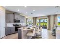 Modern kitchen with gray cabinets, island, and stainless steel appliances at 17932 Tavernside Trl, Lakewood Ranch, FL 34211