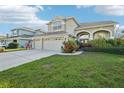 Two-story house with a three-car garage and manicured lawn at 1919 Blue River Rd, Holiday, FL 34691