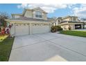Two-story house with a three-car garage and spacious driveway at 1919 Blue River Rd, Holiday, FL 34691