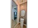 Stylish powder room with a pedestal sink and contemporary fixtures at 225 Tournament Rd, Rotonda West, FL 33947