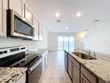 Modern kitchen featuring stainless steel appliances and granite countertops at 32535 Turtle Grace Loop, Wesley Chapel, FL 33545