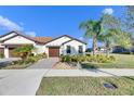Front view of a single-story house with a two-car garage and neatly landscaped yard at 5328 Stoic Vale Dr, Wimauma, FL 33598