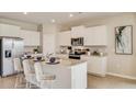Modern kitchen with white cabinets, granite island and stainless steel appliances at 5640 Silver Moonlight Dr, Palmetto, FL 34221