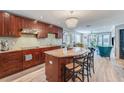 Modern kitchen with granite island, stainless steel appliances, and wood cabinets at 6332 Newtown Cir # 32A1, Tampa, FL 33615