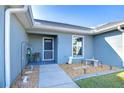 Neat walkway leading to the front door of a light blue house with landscaping at 6723 Basswood Cir, Zephyrhills, FL 33542