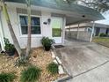 Front view of a house with a lime green door and landscaping at 883 Sky Loch S Dr, Dunedin, FL 34698