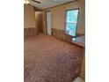 Spacious living room with neutral carpeting and wood paneling at 1463 Bobolink St, Zephyrhills, FL 33540