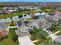 Aerial view of a two-story house with solar panels, a large backyard, and a community lake at 19354 Yellow Clover Dr, Tampa, FL 33647