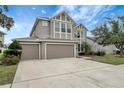 Two-story house with neutral siding, three-car garage, and landscaping at 19354 Yellow Clover Dr, Tampa, FL 33647