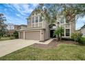 Two-story house with neutral siding, three-car garage, and landscaping at 19354 Yellow Clover Dr, Tampa, FL 33647