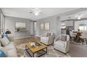 Bright living room with hardwood floors, comfortable seating, and a view into the kitchen at 2349 Grandin St, Holiday, FL 34690