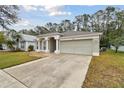 Front view of a house with a garage and landscaping at 25406 Lexington Oaks Blvd, Wesley Chapel, FL 33544