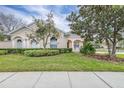 Two-story house with manicured lawn and driveway at 27325 Mistflower Dr, Wesley Chapel, FL 33544